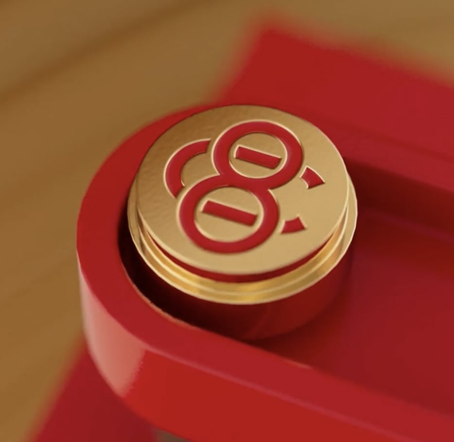 Gold circular medallion with red '8' logo on red packaging