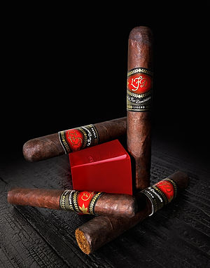 Three La Flor Dominicana cigars with LFD bands on a black background