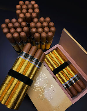 Open box of gold-wrapped cigars and loose cigars with a round logo and script text visible on the box