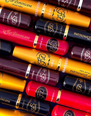 Close-up of La Flor Dominicana cigar tubos in red, yellow, and black with gold logos and branding