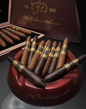 La Flor Dominicana Oro cigars arranged in a box and ashtray showing gold bands and branded ashtray