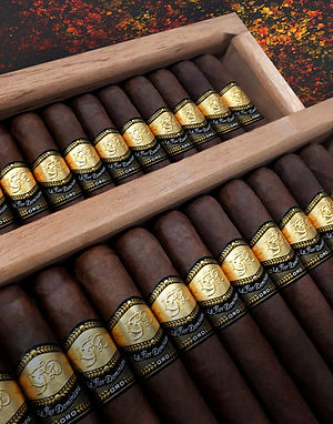 La Flor Dominicana Oro cigars with gold and black bands arranged in a wooden box